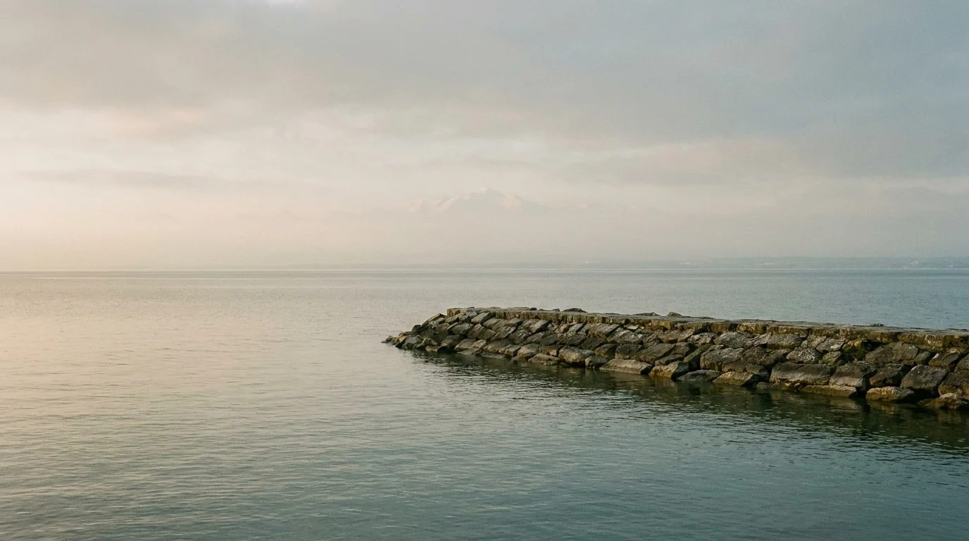 Rives du lac Léman à Versoix avec brise-lames en pierre et eau calme